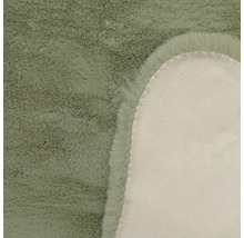 Detailansicht eines Kunstfellteppichs mit weichem Flor und der Rückseite aus Textilmaterial.