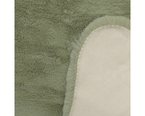 Detailansicht eines Kunstfellteppichs mit weichem Flor und der Rückseite aus Textilmaterial.