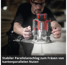 Einhell Logo auf einer Oberfräse mit stabilem Parallelanschlag beim Fräsen einer Nut in Holz mit sichtbaren Spänen.