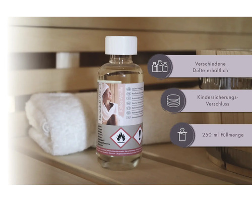 Saunaduft Kokos-Vanille in einer 250 Milliliter Flasche mit Kindersicherungs-Verschluss in einer Sauna neben einem Handtuch und einem Holzkübel.
