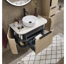Moderner, gut organisierter Waschtisch mit rundem Aufsatzbecken, geöffneter Schublade, geschwungenen Seitenregalen und Fronten in Holzoptik.
