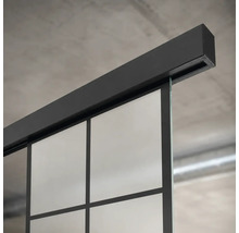 Schiebetürsystem mit schwarzer Laufschiene und Glastür mit Sprossen im Industrial-Design.