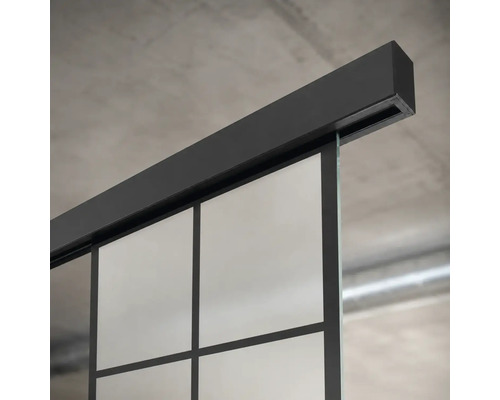 Schiebetürsystem mit schwarzer Laufschiene und Glastür mit Sprossen im Industrial-Design.