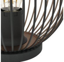 Nahaufnahme einer Tischleuchte im Industriedesign mit einem Metallkäfig aus schwarzen und bronzefarbenen Streben sowie einer E27 Fassung.