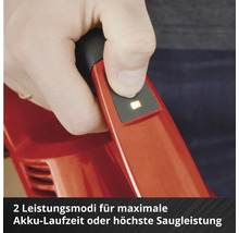 Hand bedient den Knopf am Griff eines roten Akku-Staubsaugers zur Auswahl von zwei Leistungsmodi für Akkulaufzeit und Saugleistung.