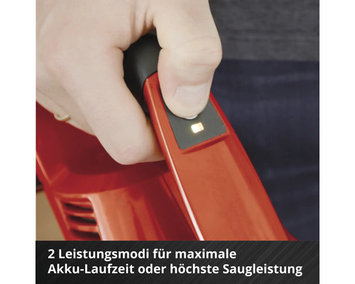 Hand bedient den Knopf am Griff eines roten Akku-Staubsaugers zur Auswahl von zwei Leistungsmodi für Akkulaufzeit und Saugleistung.