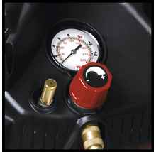 Detailansicht von Manometer und rotem Druckregler an einem Kompressor mit Messinganschlüssen.