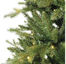 Nahaufnahme der Zweige eines künstlichen Weihnachtsbaums mit integrierter warmweißer LED-Beleuchtung.