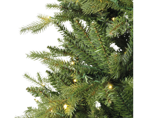 Nahaufnahme der Zweige eines künstlichen Weihnachtsbaums mit integrierter warmweißer LED-Beleuchtung.