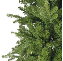 Detailaufnahme der dichten, realistisch wirkenden grünen Zweige eines künstlichen Weihnachtsbaums.