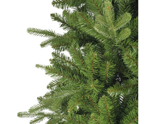 Detailaufnahme der dichten, realistisch wirkenden grünen Zweige eines künstlichen Weihnachtsbaums.