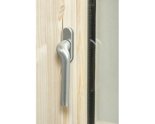 Detailaufnahme eines silberfarbenen Fenstergriffs an einem Holzfensterrahmen aus Kiefernholz.