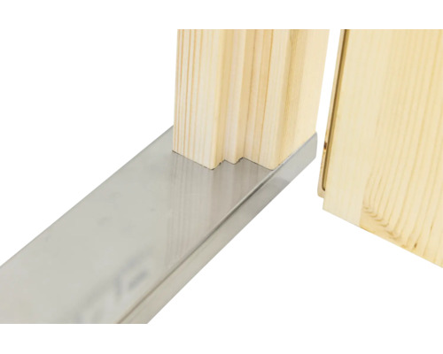 Nahaufnahme einer metallenen Türschwelle an einer profilierten Türzarge aus hellem Holz.