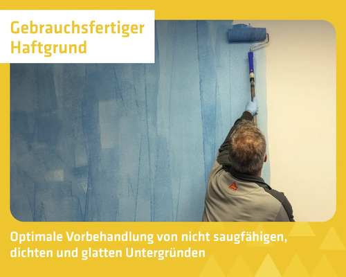Eine Person trägt mit einer Farbrolle gebrauchsfertigen Haftgrund auf eine Wand auf, zur Vorbehandlung von glatten Untergründen.