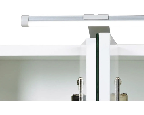 Detailansicht eines Schrankinneren mit LED-Leiste oben, weißen Türen und Scharnieren aus Metall.