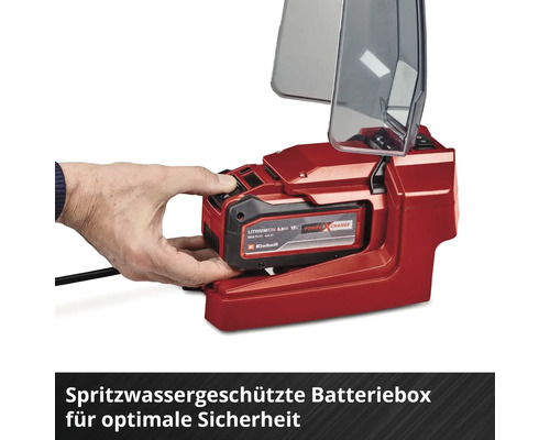 Hand setzt einen Einhell Power X-Change 18 Volt Akku in eine spritzwassergeschützte Batteriebox mit geöffnetem Klarsichtdeckel ein.