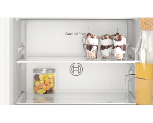 Innenansicht eines Bosch Kühlschranks mit CoolAirflow Funktion, gefüllten Dessertgläsern, Obstbehälter und Flasche auf den Ablagen.