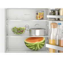 Innenansicht eines Bosch Kühlschranks mit CoolAirflow, gefüllt mit Lebensmitteln wie Obst, Gemüse, einem Topf und Getränken.