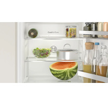 Innenansicht eines Bosch Kühlschranks mit CoolAirflow Technologie, gefüllt mit Lebensmitteln, Glasbehältern und einer halben Wassermelone.
