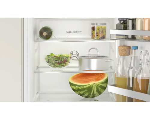 Innenansicht eines Bosch Kühlschranks mit CoolAirflow Technologie, gefüllt mit Lebensmitteln, Glasbehältern und einer halben Wassermelone.