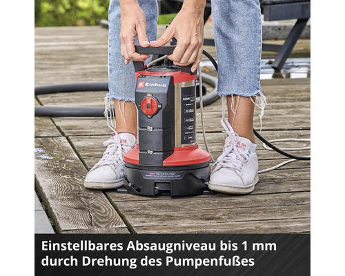 Einhell Schmutzwasserpumpe auf einer Holzterrasse mit einem bis zu einem Millimeter einstellbaren Absaugniveau durch Drehen des Pumpenfußes.