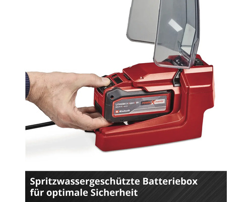 Hand setzt einen Einhell Power X-Change Akku in das spritzwassergeschützte Akkufach mit geöffneter transparenter Abdeckung ein.