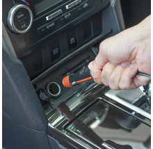 Eine Hand steckt einen 12-Volt-Kfz-Stecker in den Zigarettenanzünder eines Autos.