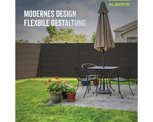 Moderner Alberts Sichtschutzzaun in dunkler Holzoptik im Garten hinter einer gemütlichen Sitzecke mit Blumen.