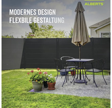 Alberts Sichtschutzzaun in Anthrazit im Garten hinter einer Sitzgruppe mit Tisch, Stühlen und Sonnenschirm.
