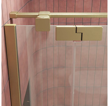 Duschwand aus Glas mit mattem goldfarbenem Profil und Wandanschluss in einer gefliesten Duschkabine