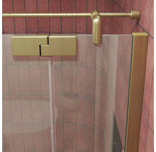 Duschwand aus Glas mit goldenen Beschlägen und Stabilisierungsstange vor gefliesten Wänden