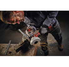 Handwerker mit Schutzbrille nutzt Einhell Akku Winkelschleifer zum Trennen von Metall in einem Schraubstock mit Funkenflug in der Werkstatt