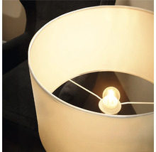 Moderne Stehlampe mit zylindrischem Lampenschirm aus Stoff und integriertem Leuchtmittel für eine helle Raumbeleuchtung.