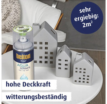 Eine Spraydose Belton Free Aqua Colours Lack mit drei dekorativen Häuserfiguren auf einem Tisch mit Informationen zu Ergiebigkeit und Deckkraft.