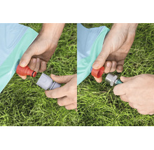 Hände beim Anschluss eines Gartenschlauchs an ein aufblasbares Produkt mit verschiedenen Steckverbindungen über einer Rasenfläche