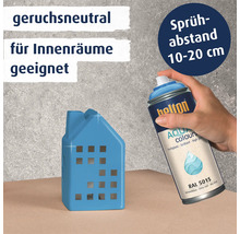 Eine Hand sprüht mit Helton Aqua Colours Lack in Himmelsblau auf ein kleines Deko Haus.