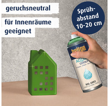 Hand hält eine Helton Aqua Colours Sprühdose in Laubgrün RAL 6002 zum Lackieren eines Hausmodells. Produkt ist geruchsneutral für Innenräume.