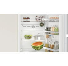 Geöffneter Bosch Kühlschrank mit CoolAirflow Technologie, gefüllt mit Lebensmitteln, Flaschen und einer Wassermelone auf den Ablagen.