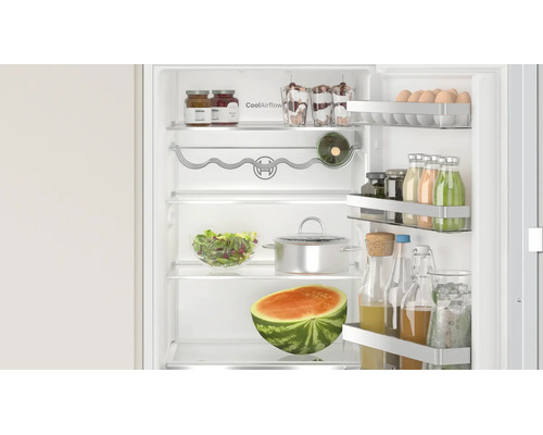 Geöffneter Bosch Kühlschrank mit CoolAirflow Technologie, gefüllt mit Lebensmitteln, Flaschen und einer Wassermelone auf den Ablagen.