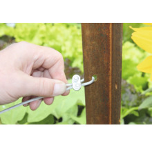 Hand befestigt Drahtseil mit Drahtseilklemme an einem Metallpfosten im Garten.