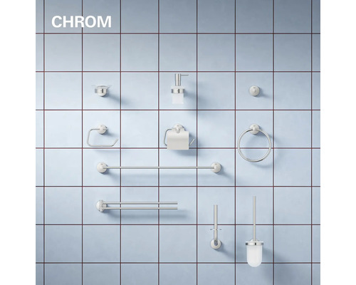 Badezimmer Zubehör Set aus Metall in Chrom Optik, montiert an einer gefliesten Wand, bestehend aus Seifenspender, Handtuchhaltern und WC Bürste.