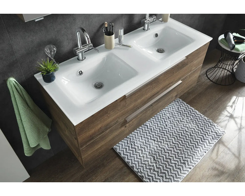 Doppelwaschtisch mit weißem Keramikbecken und Unterschrank in Holzoptik mit zwei Auszügen in einem modern eingerichteten Badezimmer.