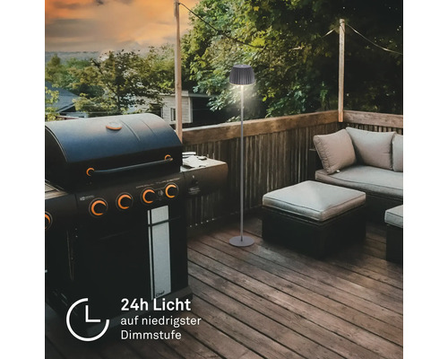 Moderne Outdoor Stehlampe auf einer Terrasse neben einem Gasgrill und Lounge Möbeln mit einer Laufzeit von 24 Stunden bei niedrigster Dimmstufe.