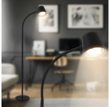 Moderne Stehlampe mit gebogenem Arm und rundem Lampenschirm in einem stilvoll eingerichteten Wohnraum