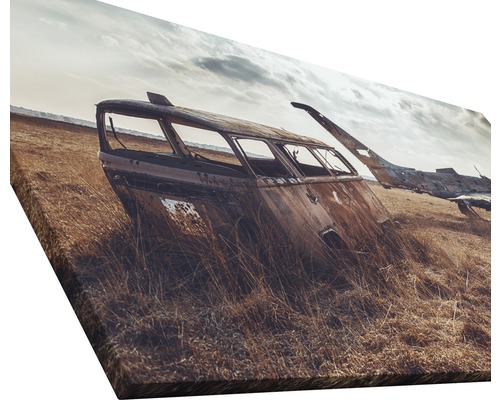 Leinwanddruck mit dem Motiv eines verrosteten Autowracks in einem Feld.