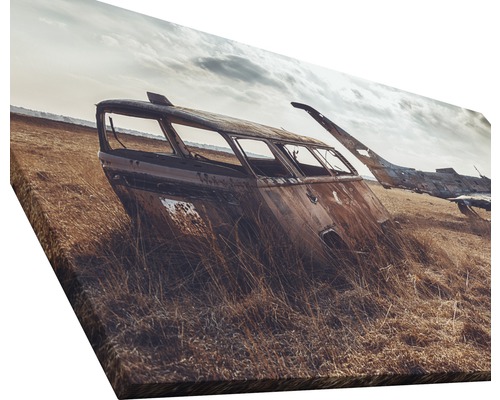 Leinwandbild mit Wrack eines verrosteten Busses in einem Feld.