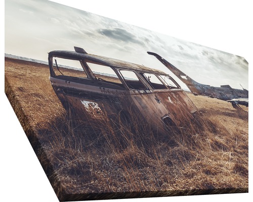Leinwanddruck mit Abbildung eines verrosteten Autowracks im Feld