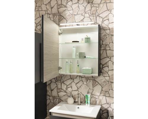 Badezimmer mit Waschbeckenunterschrank, Waschbecken und Spiegelschrank mit offen stehender Tür