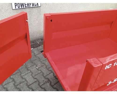 Detailansicht eines roten Anhängers mit offener Ladefläche.