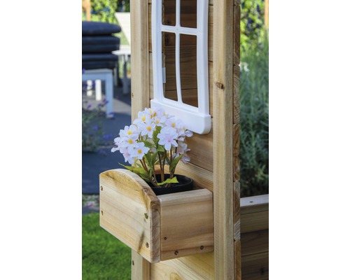 Detailansicht eines Holzspielhauses mit Fenster, Blumenkasten und künstlichen Blumen